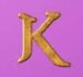 Symbol Písmeno K automatu Thrones of Persia od Tom Horn Gaming